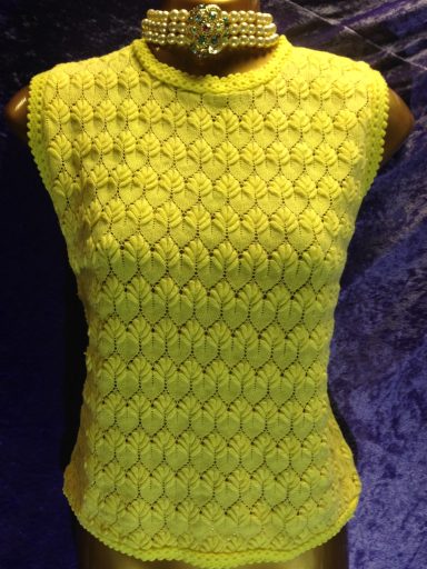 A bright yellow knitted sleeveless top with a textured pattern.
