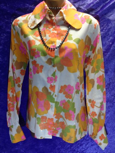 Retro floral blouse with large collar in vibrant orange, pink, and white colours.